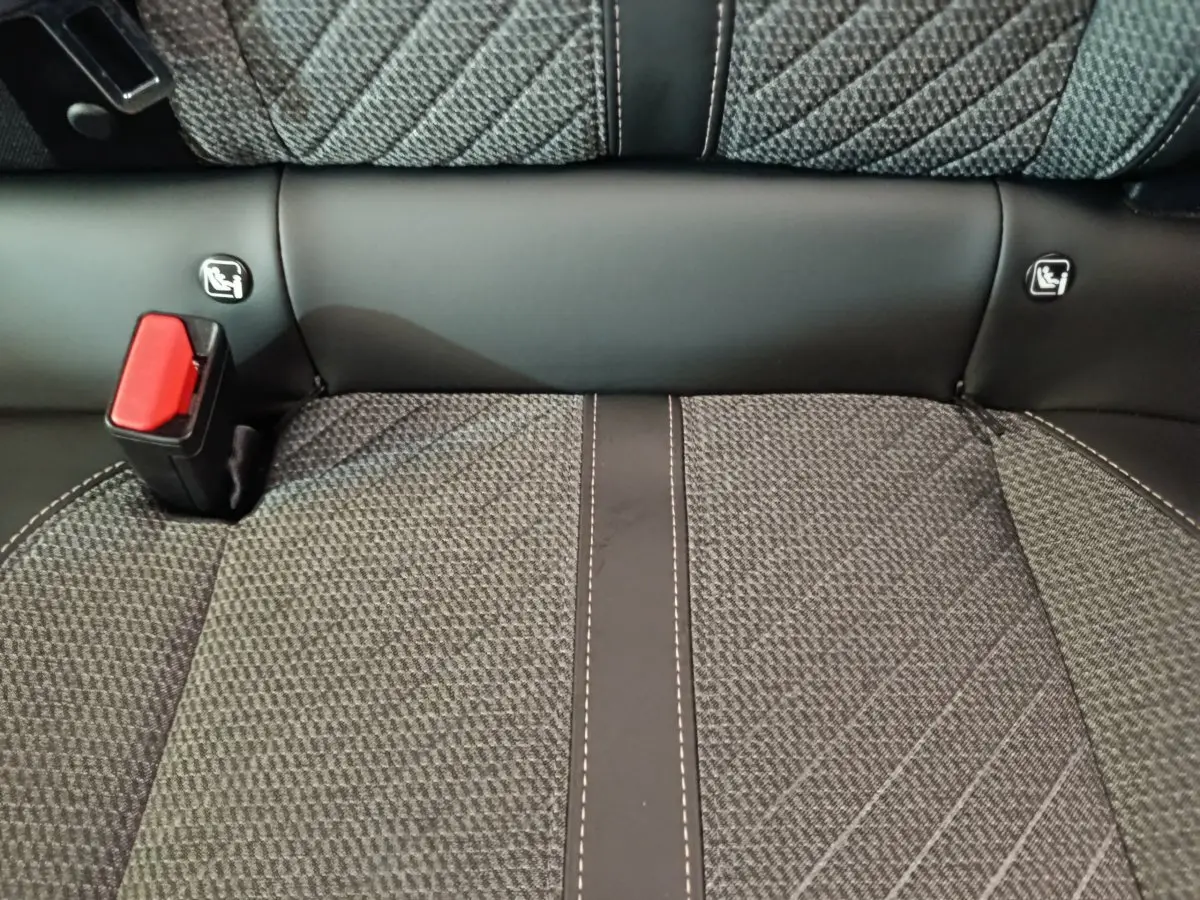 Gros plan sur la banquette arrière grise avec coutures contrastées et attaches Isofix visibles sur une Peugeot 208.