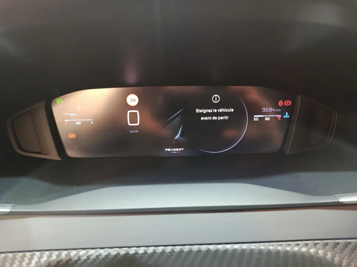 Vue rapprochée du combiné d'instruments numérique de la Peugeot 208 PureTech 100 S&S Allure affichant 9684 km et alertes.
