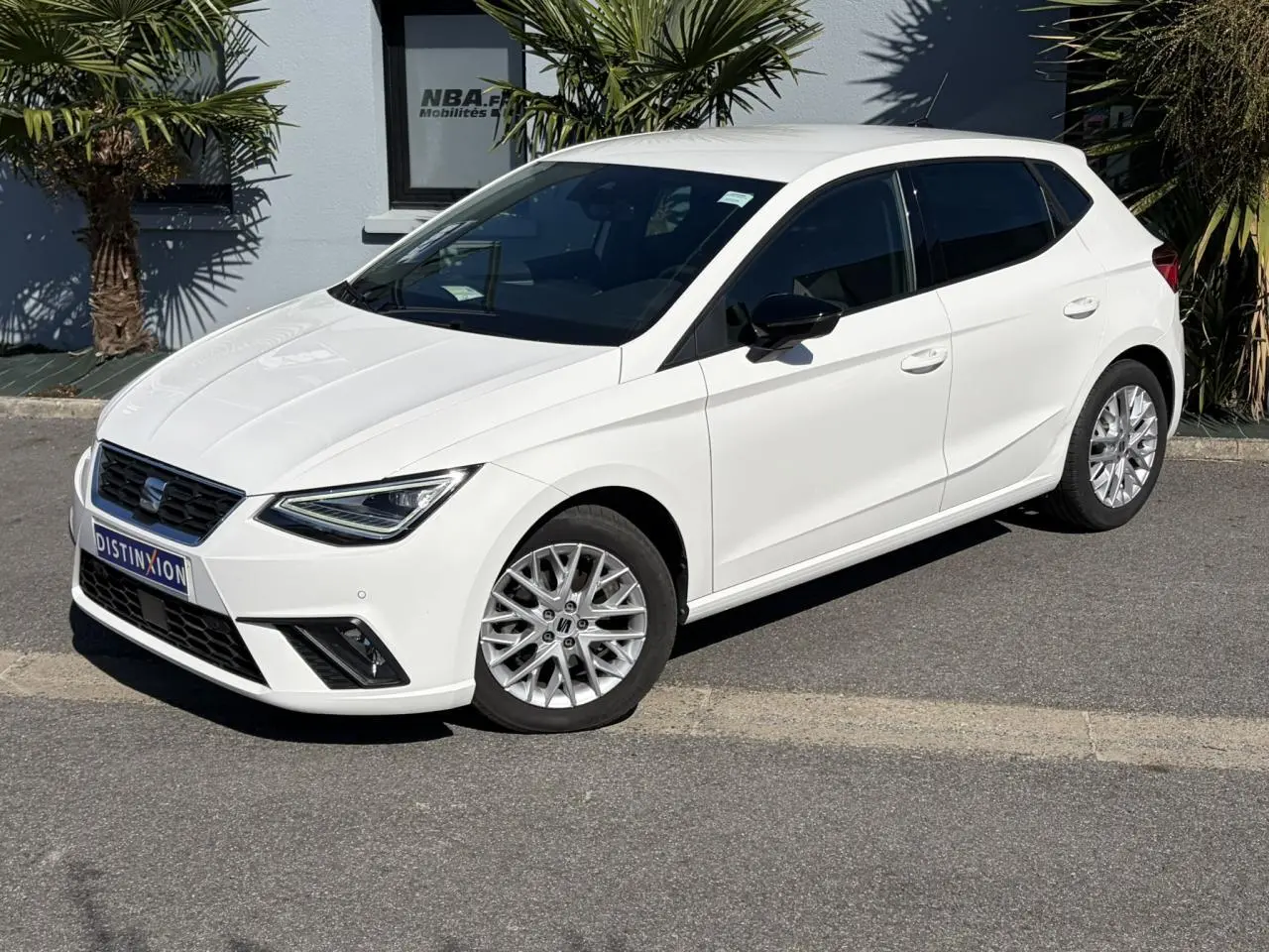 SEAT Ibiza TSI 115 FR blanc Candy vue 3/4 avant droit avec jantes alliage et vitres arrière surteintées.
