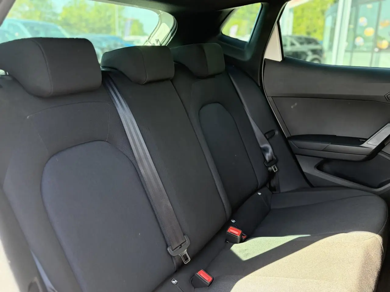 Vue intérieure côté droit de la banquette arrière noire de la SEAT Ibiza TSI 115 FR 2025, avec ceintures et appuie-têtes.