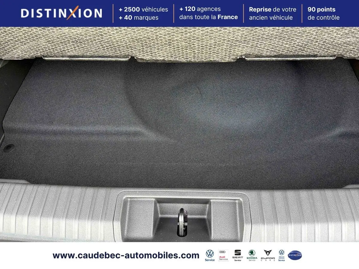 Coffre ouvert d’une Renault Symbioz gris, vue plongeante sur le compartiment de rangement avec tapis noir.