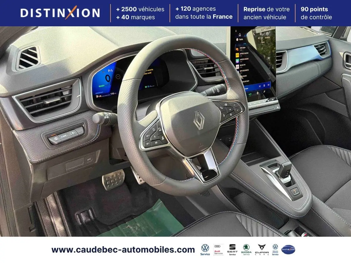 Intérieur de la Renault Symbioz gris, vue du poste de conduite avec volant multifonction et écran tactile vertical.