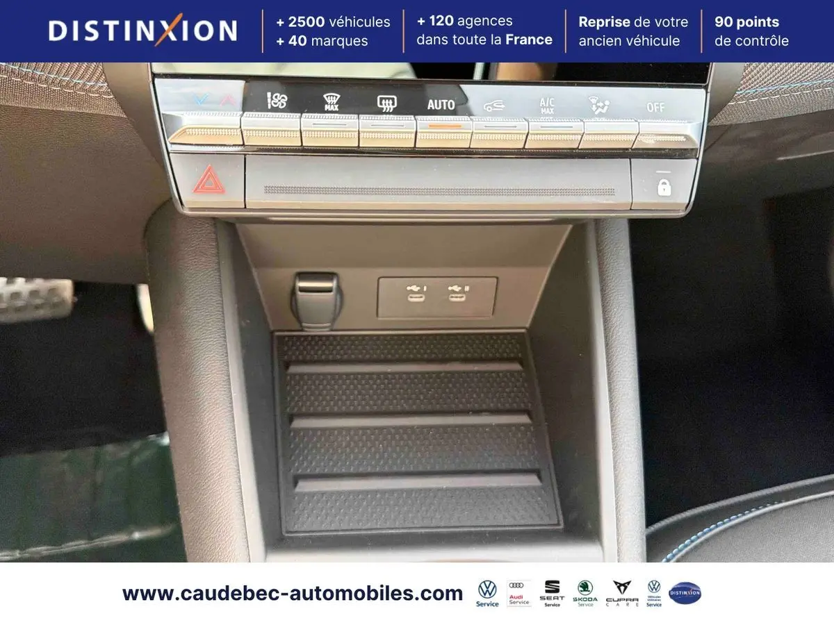 Vue rapprochée de la console centrale noire de la Renault Symbioz E-Tech avec commandes climatisation et ports USB visibles.
