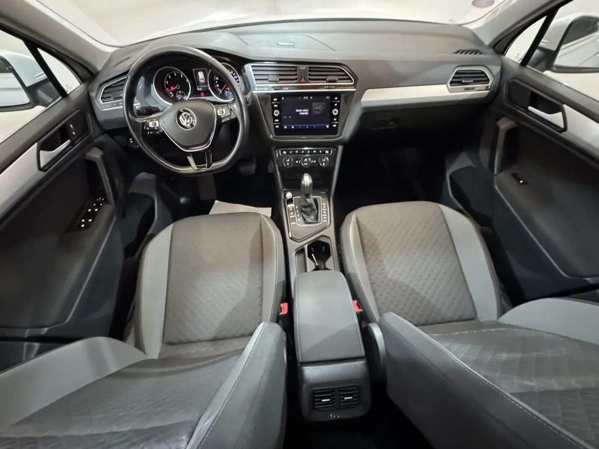 Intérieur du Volkswagen Tiguan 2020 vu de face, montrant tableau de bord, écran tactile et sièges gris.
