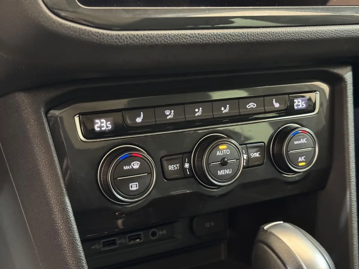 Gros plan sur la console centrale du Volkswagen Tiguan blanc 2020, montrant les commandes de climatisation digitale à 3 zones.