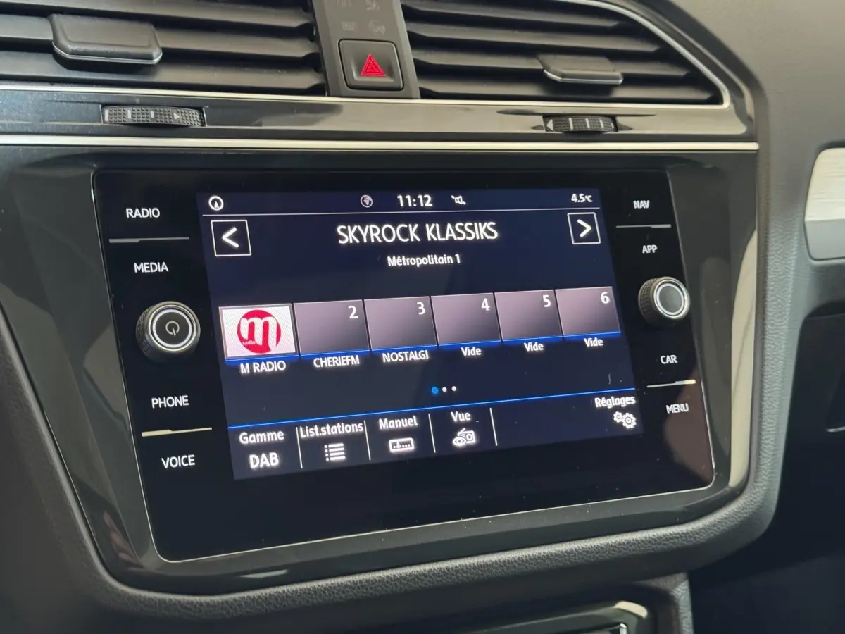 Écran tactile central du Volkswagen Tiguan blanc 2020 affichant la radio Skyrock Klassiks en intérieur voiture.