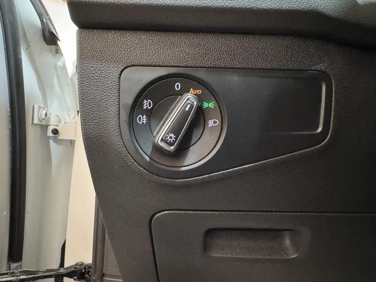 Gros plan sur la commande des phares à gauche du tableau de bord d'un Volkswagen Tiguan blanc 2020.