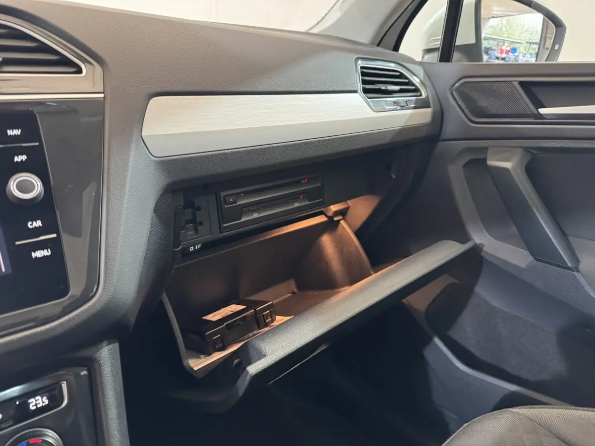 Intérieur du Volkswagen Tiguan 1.5 TSI 2020, vue sur la boîte à gants ouverte côté passager avec tableau de bord gris.