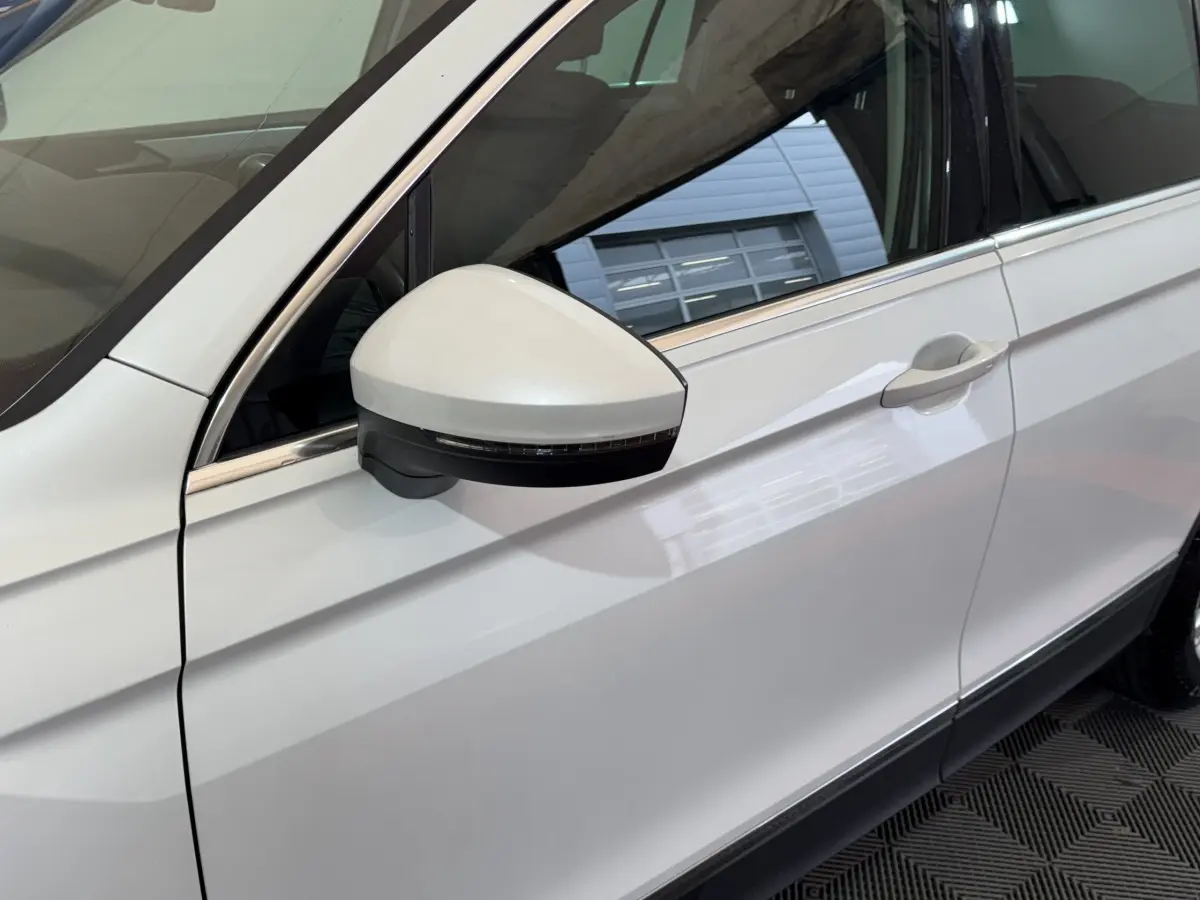 Vue rapprochée du côté gauche blanc du Volkswagen Tiguan 2020, mettant en valeur le rétroviseur avec clignotant intégré.