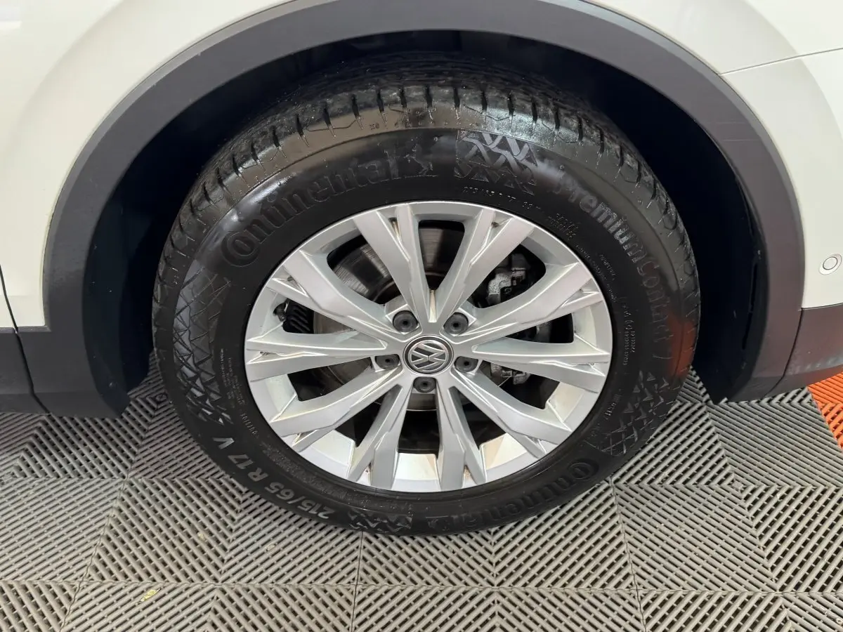 Gros plan sur la roue arrière droite du Volkswagen Tiguan blanc, avec jante alliage et pneu Continental.