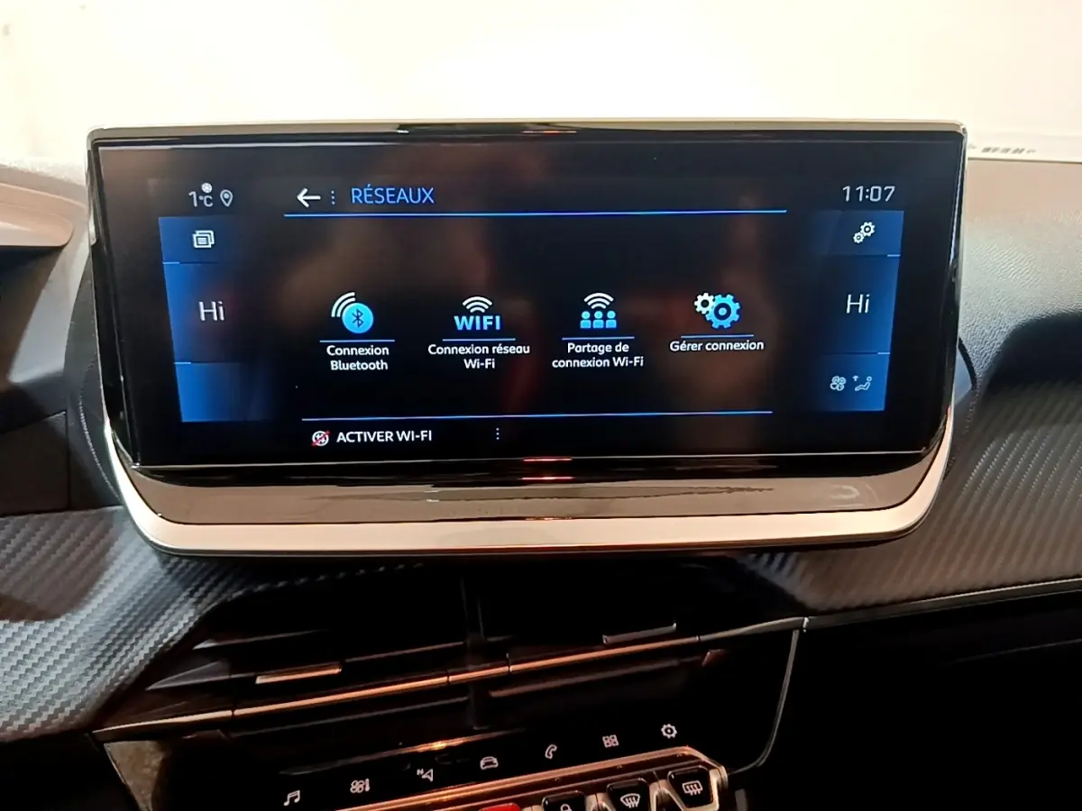 Écran tactile central de la Peugeot 208 jaune, affichant les options de connexion Bluetooth et Wi-Fi.