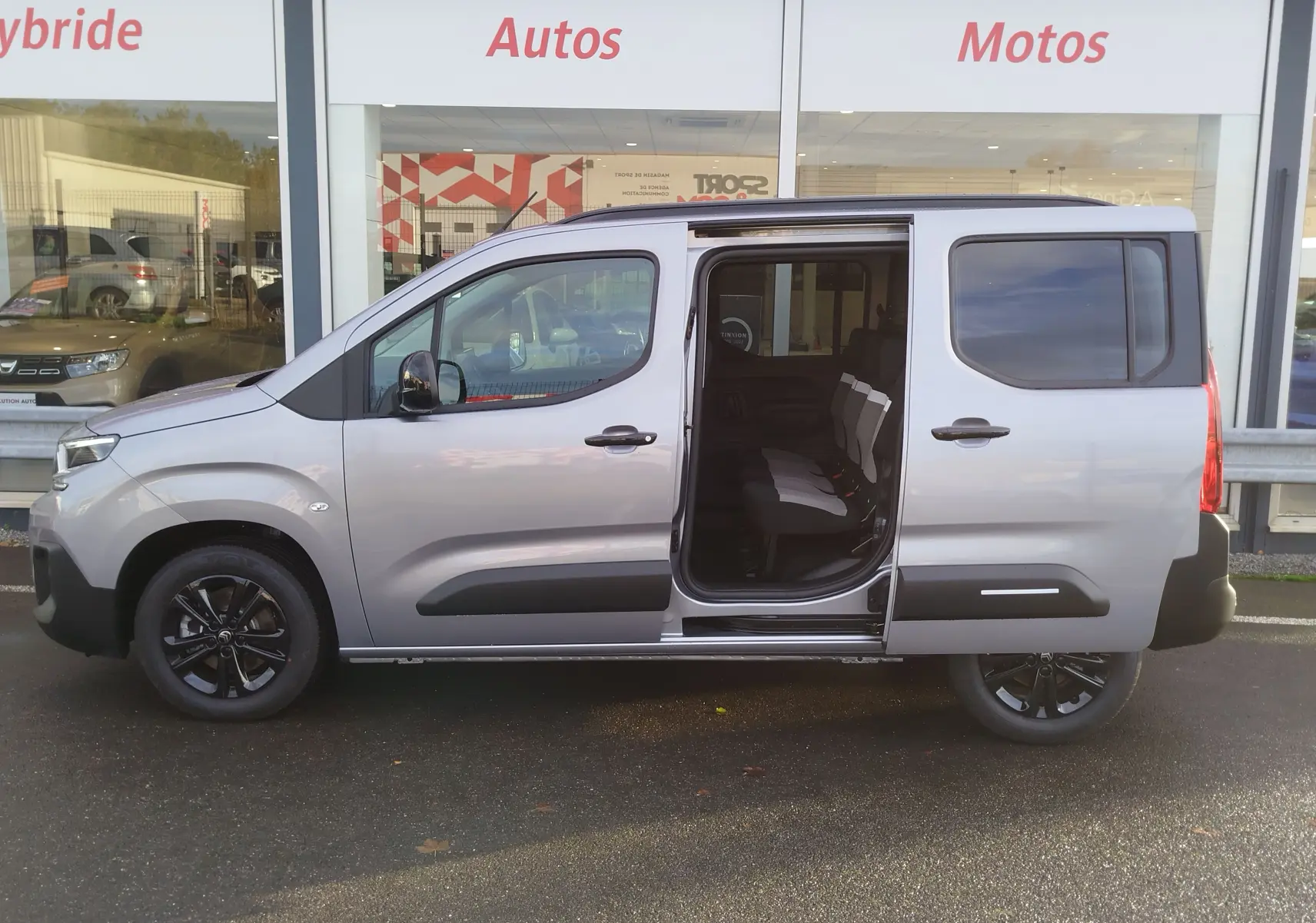 Vue latérale droite du Citroën Berlingo gris acier 2025 avec porte coulissante ouverte révélant les sièges arrière.