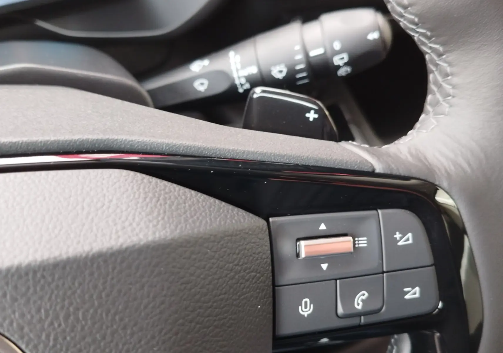 Gros plan sur les commandes du volant du Citroën Berlingo 2025, finition gris acier, avec boutons de volume et téléphone.