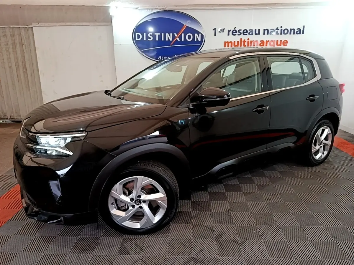 Vue 3/4 avant droit d’un Citroën C5 Aircross hybride rechargeable noir, avec jantes alliage et logo H bleu sur aile.