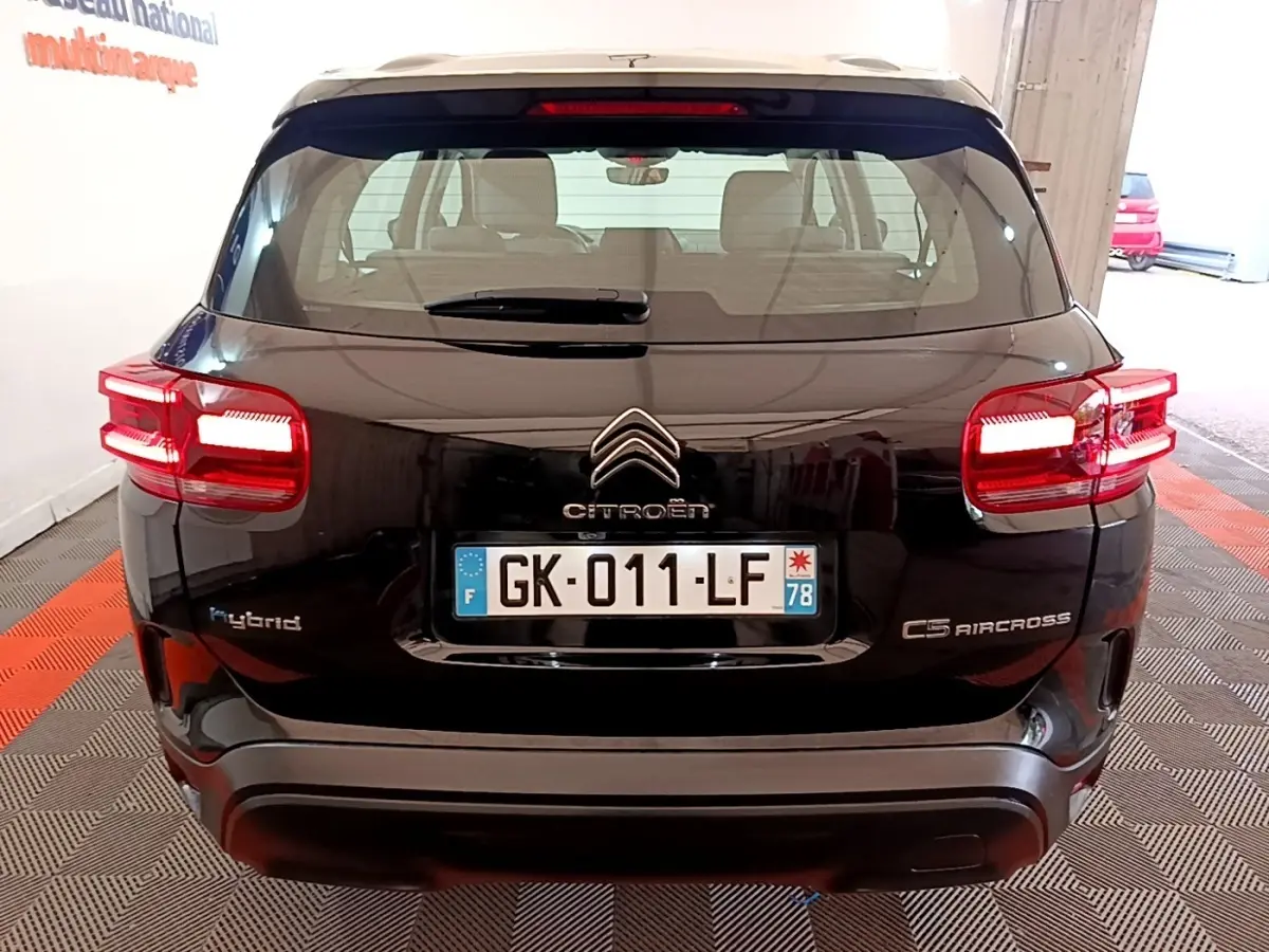 Vue arrière d'un Citroën C5 Aircross hybride rechargeable noir, avec feux arrière allumés et plaques d'immatriculation visibles.