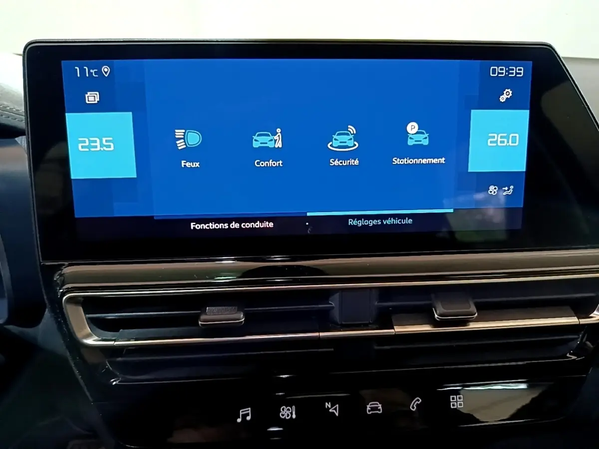 Vue rapprochée de l'écran tactile central bleu du tableau de bord du Citroën C5 Aircross hybride rechargeable noir, affichant les réglages de conduite.