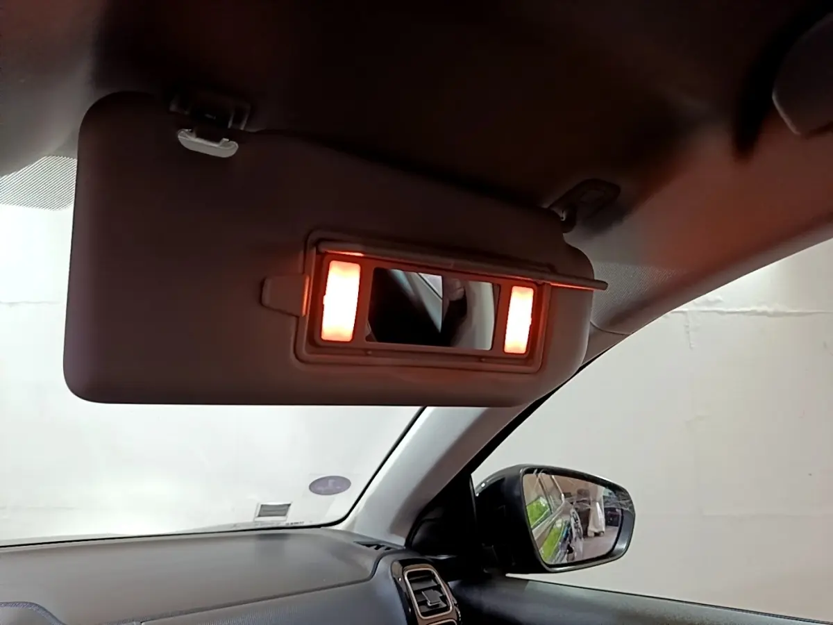 Intérieur du Citroën C5 Aircross hybride noir, vue côté passager avec pare-soleil et miroir éclairé.