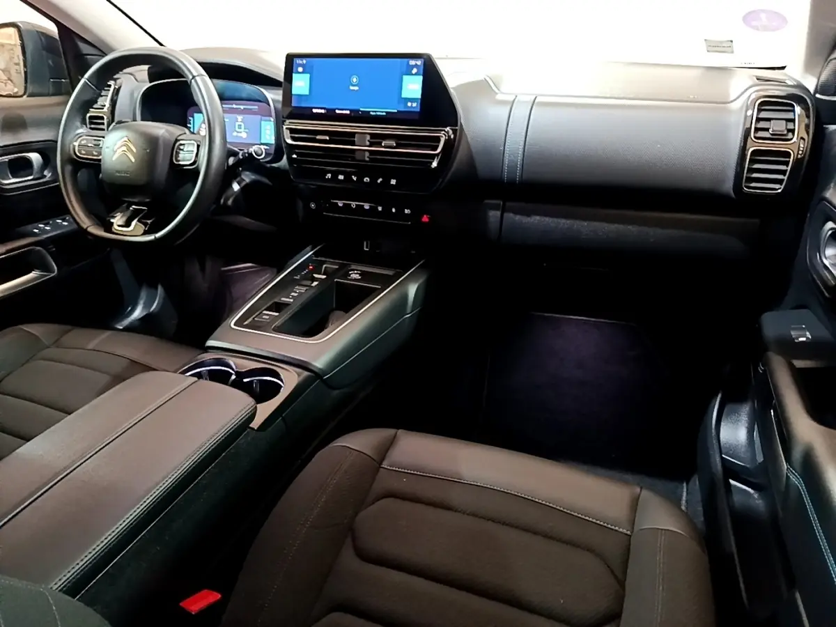 Vue intérieure côté conducteur du Citroën C5 Aircross hybride noir, avec tableau de bord digital et écran tactile central.