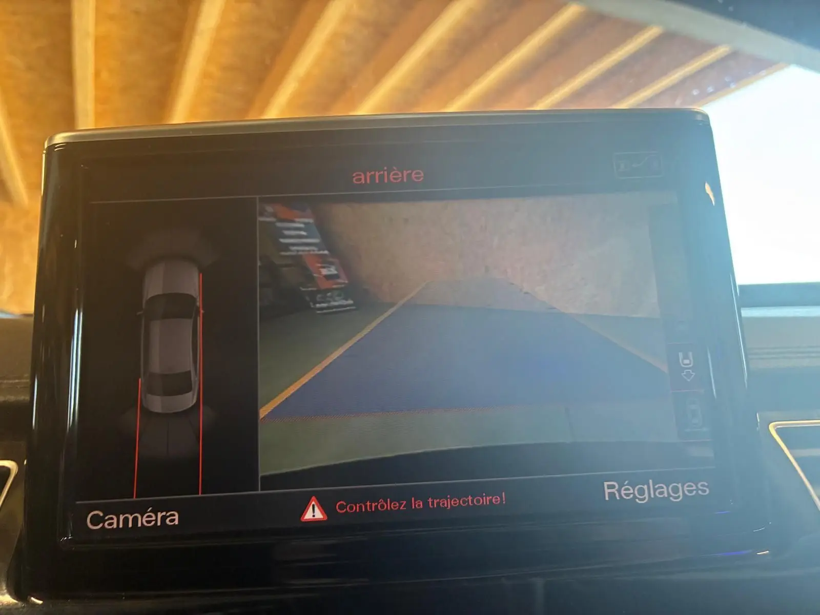 Écran de caméra de recul dans une Audi A8 noire 2016, affichant la vue arrière avec guidage de trajectoire.