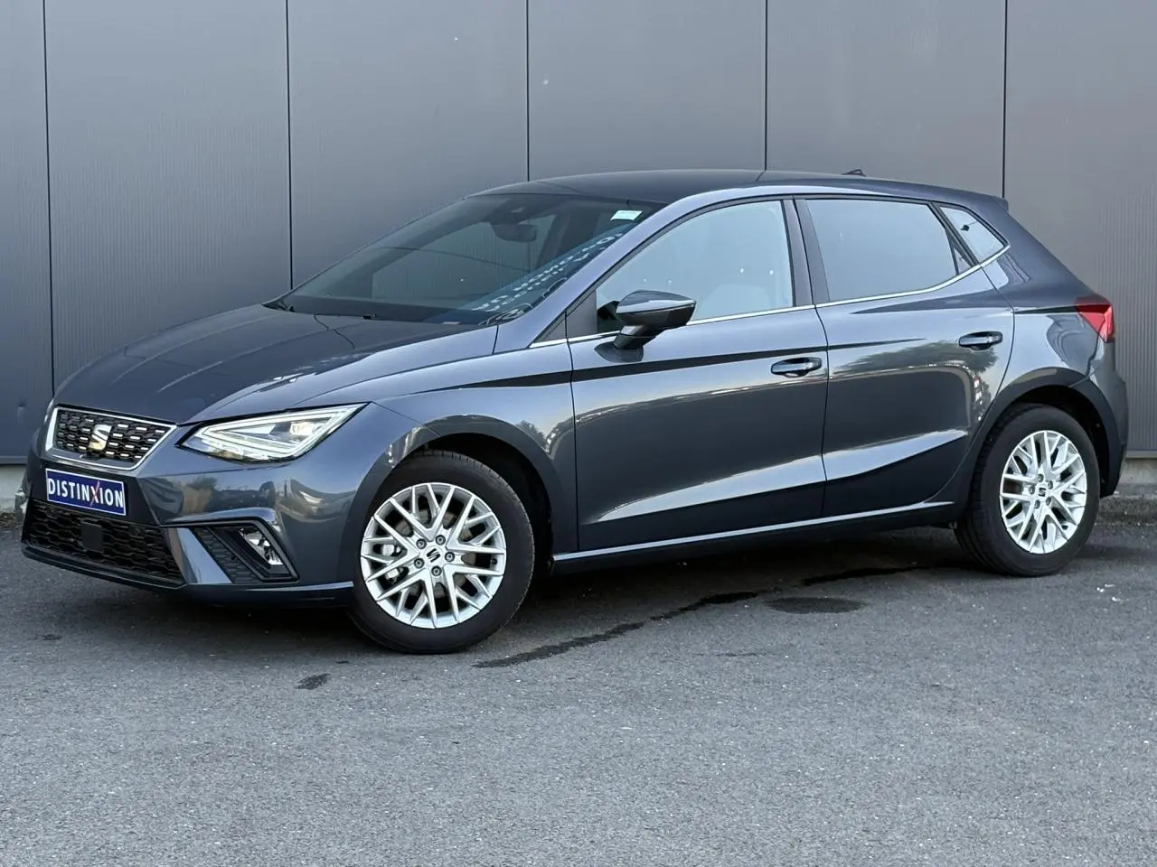 SEAT Ibiza TSI 115 Xcellence gris magnétique vue 3/4 avant avec jantes alliage 16 pouces et vitres surteintées.