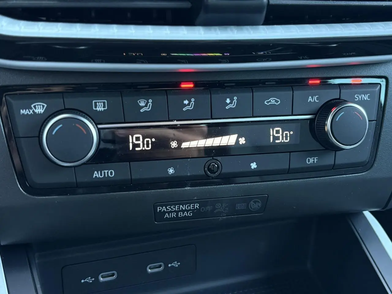 Gros plan sur la commande de climatisation bi-zone noire avec affichage digital à 19°C dans une SEAT Ibiza gris magnétique.