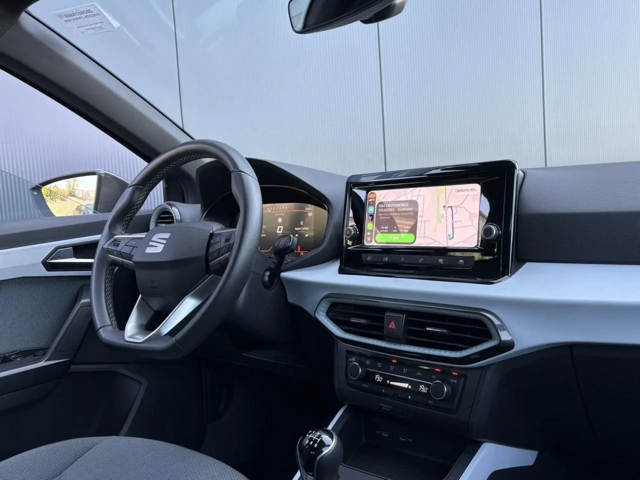Vue intérieure côté conducteur de la SEAT Ibiza TSI 115 Xcellence 2025, volant cuir multifonction et écran tactile central.
