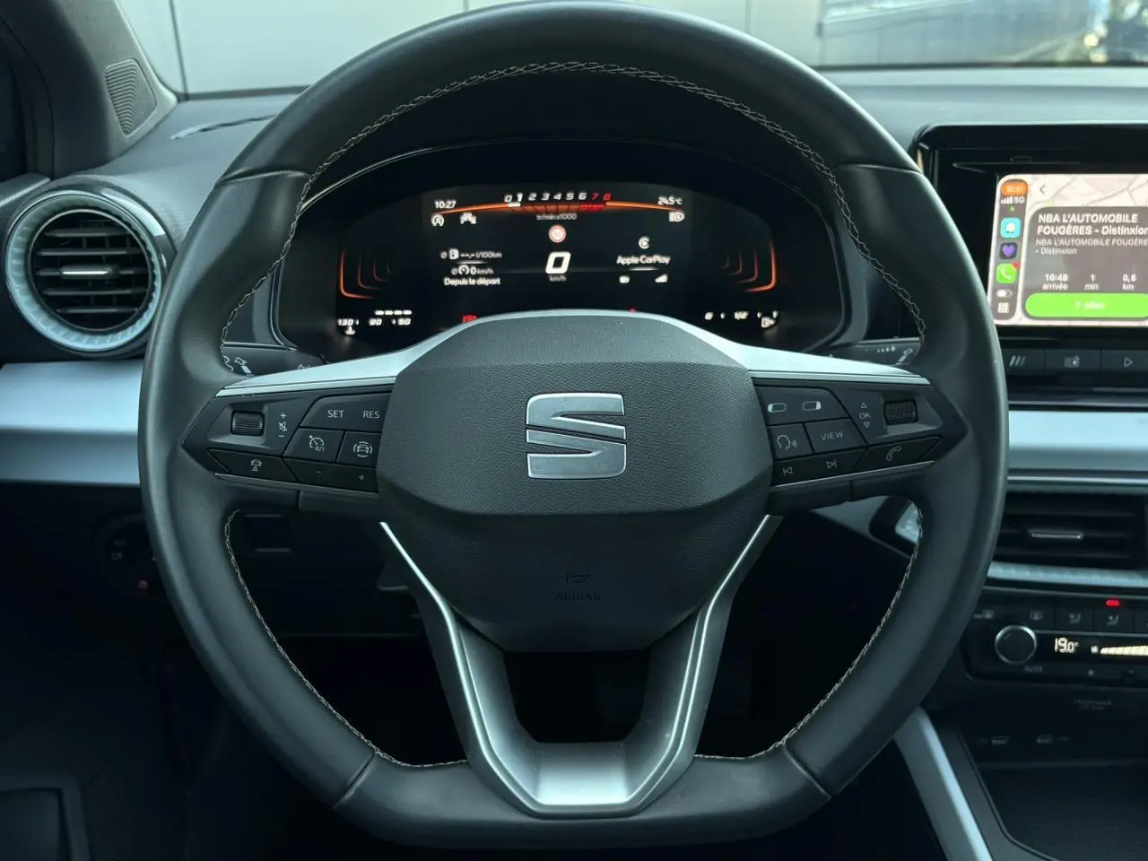 Vue rapprochée du volant cuir multifonction de la SEAT Ibiza 2025 avec tableau de bord digital et écran tactile à droite.