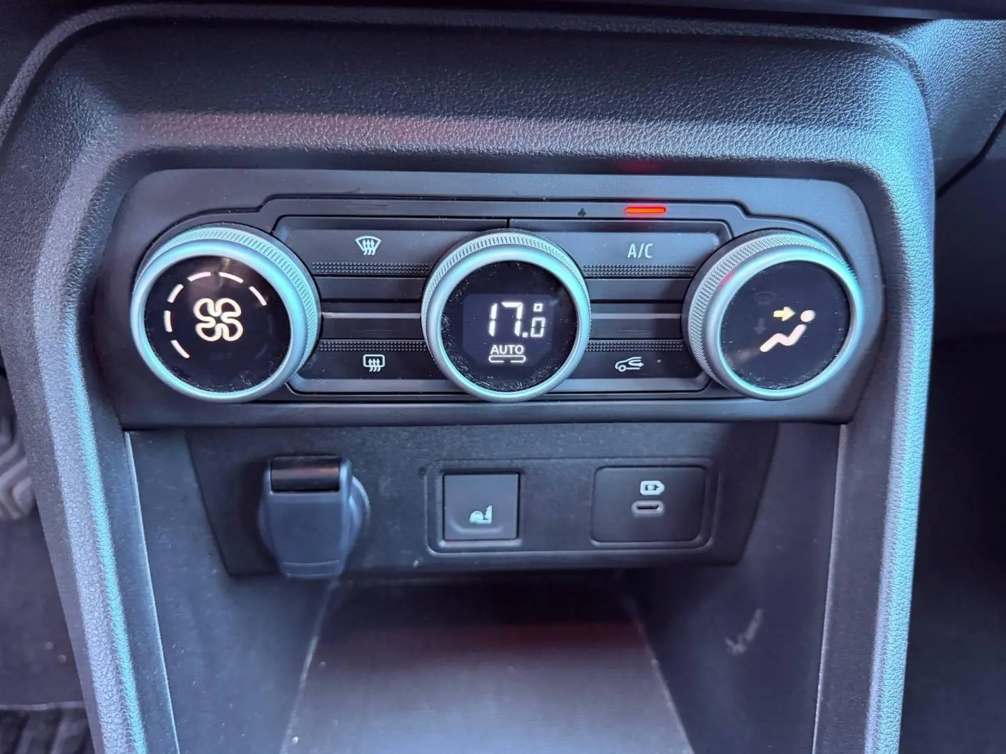 Vue rapprochée des commandes de climatisation automatique de la Dacia Sandero 2025, boutons ronds noirs avec affichage digital.