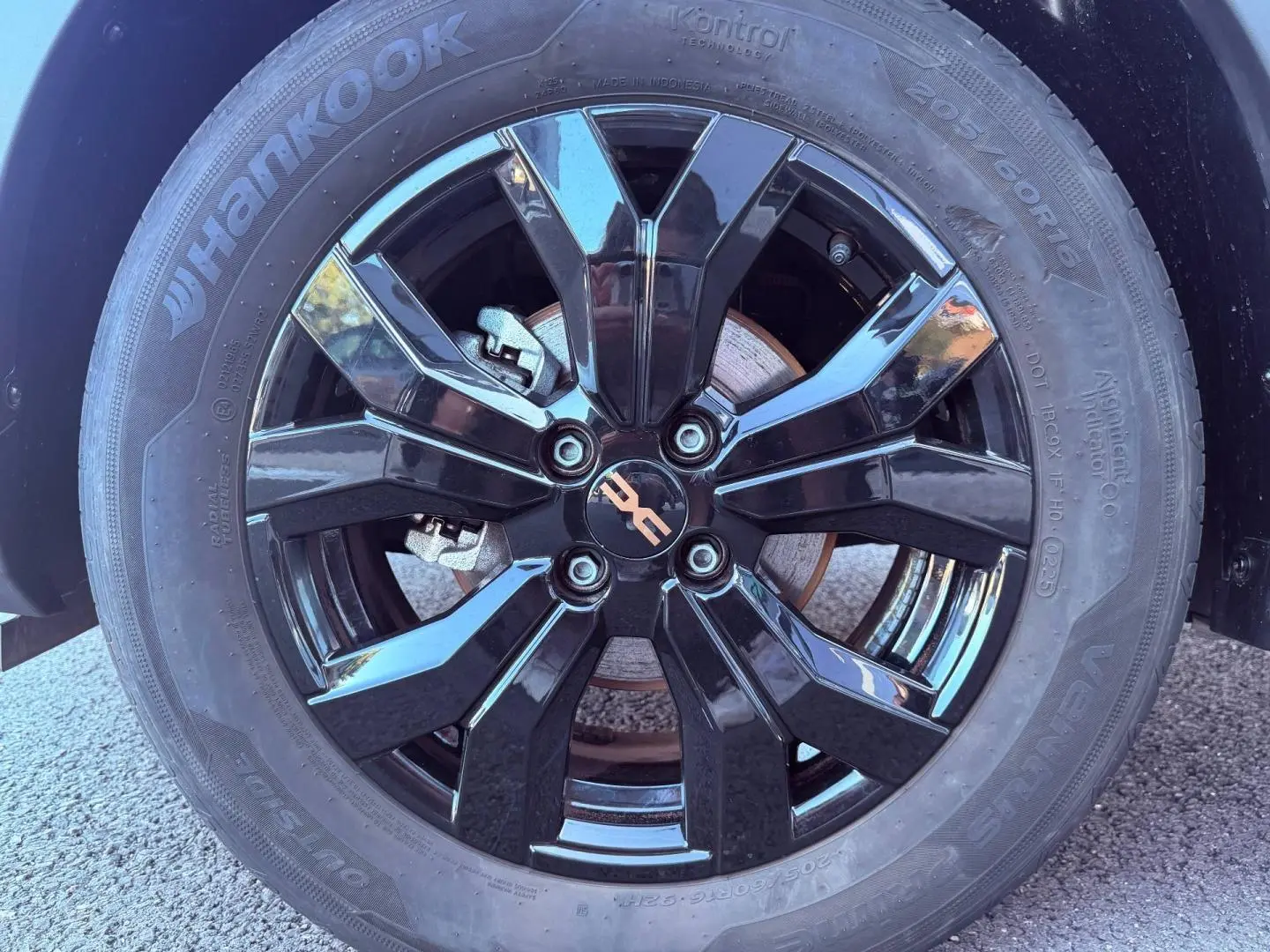 Gros plan sur la jante noire brillante de la Dacia Sandero 1.0 ECO-G 100ch Stepway Extreme, avec logo central cuivré.