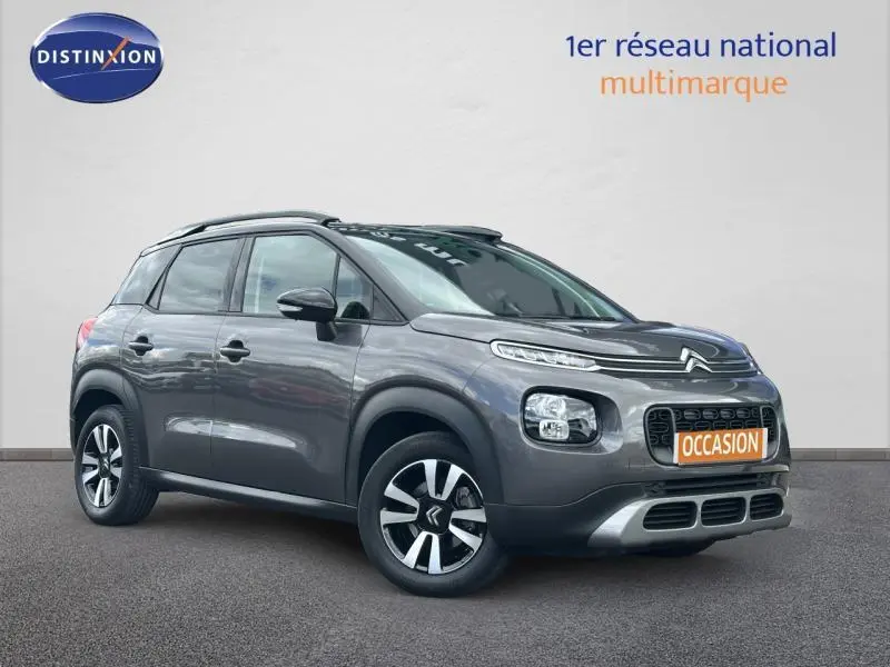 SUV Citroën C3 Aircross gris en 3/4 avant droit avec barres de toit et jantes alliage noires et argentées