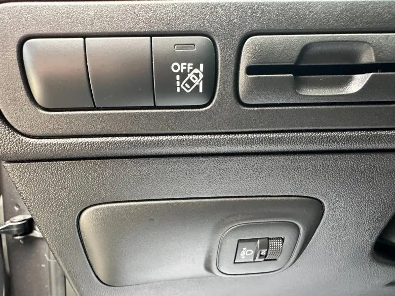 Gros plan sur les commandes noires de réglage des aides à la conduite et des phares du Citroën C3 Aircross 2021.