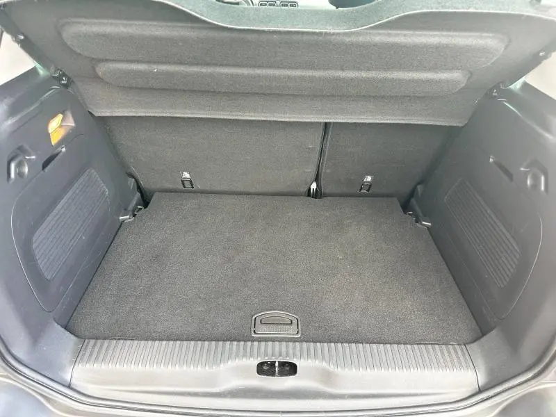 Coffre ouvert vu de l'arrière d'une Citroën C3 Aircross 2021, surface de chargement noire et banquette arrière rabattue.