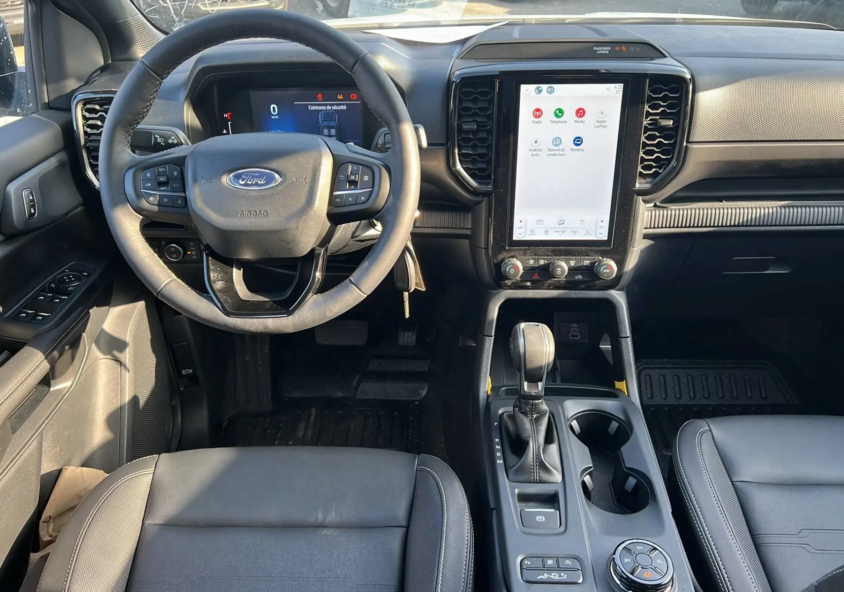 Intérieur du Ford Ranger 2025 vu de face, tableau de bord moderne avec écran tactile vertical et volant multifonctions.