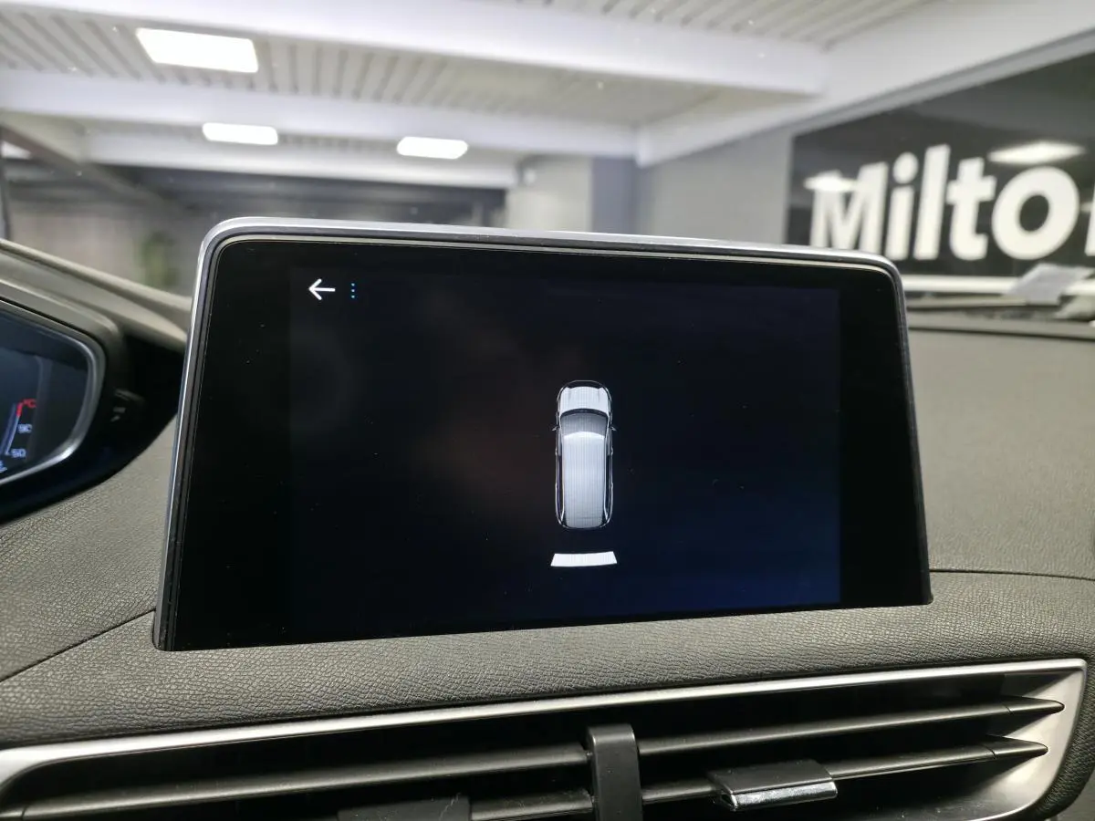 Écran tactile central affichant l'aide au stationnement du Peugeot 5008 bleu, vue intérieure du tableau de bord.