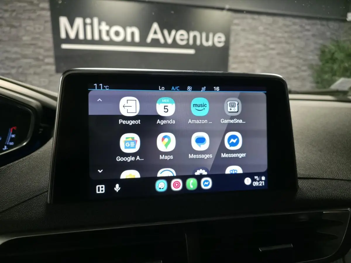 Écran tactile central du Peugeot 5008 bleu de 2019 affichant des applications connectées, intérieur sombre.