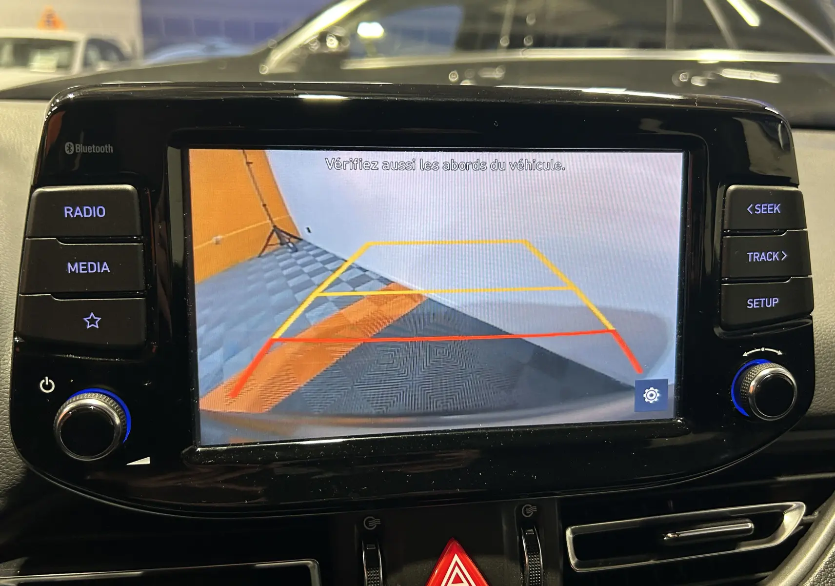 Écran de caméra de recul dans une Hyundai i30 SW 2022, affichant les lignes de guidage en intérieur de garage.
