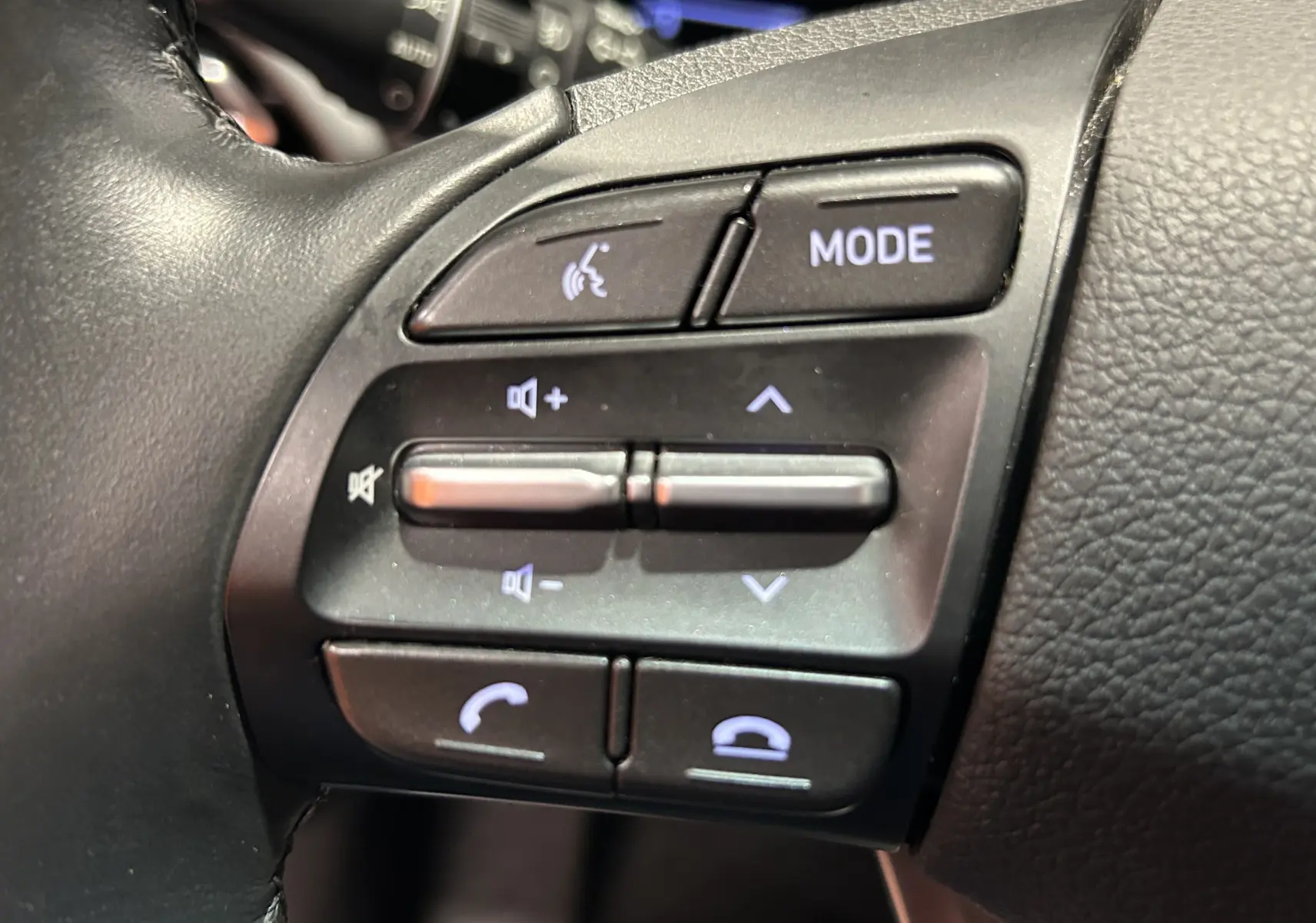 Gros plan sur les commandes noires du volant côté gauche de la Hyundai i30 SW 2022, finition Family Smart.