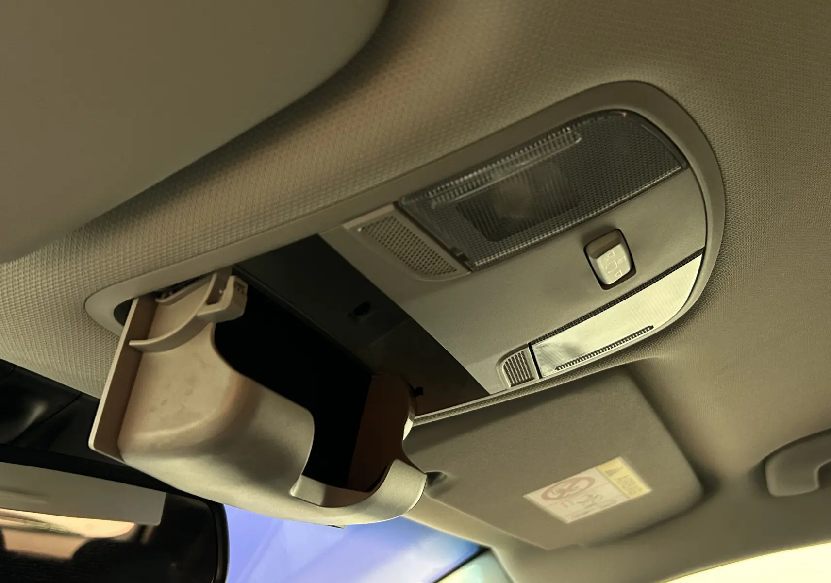Gros plan sur le rangement lunettes ouvert au plafond intérieur de la Hyundai i30 SW 2022, finition gris clair.