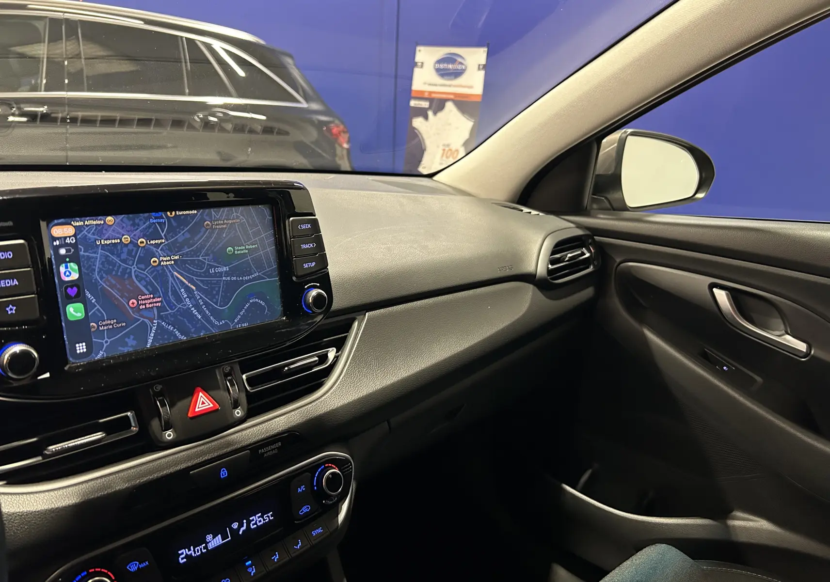 Vue intérieure côté passager de la Hyundai i30 SW 2022, avec écran tactile et commandes de climatisation visibles.