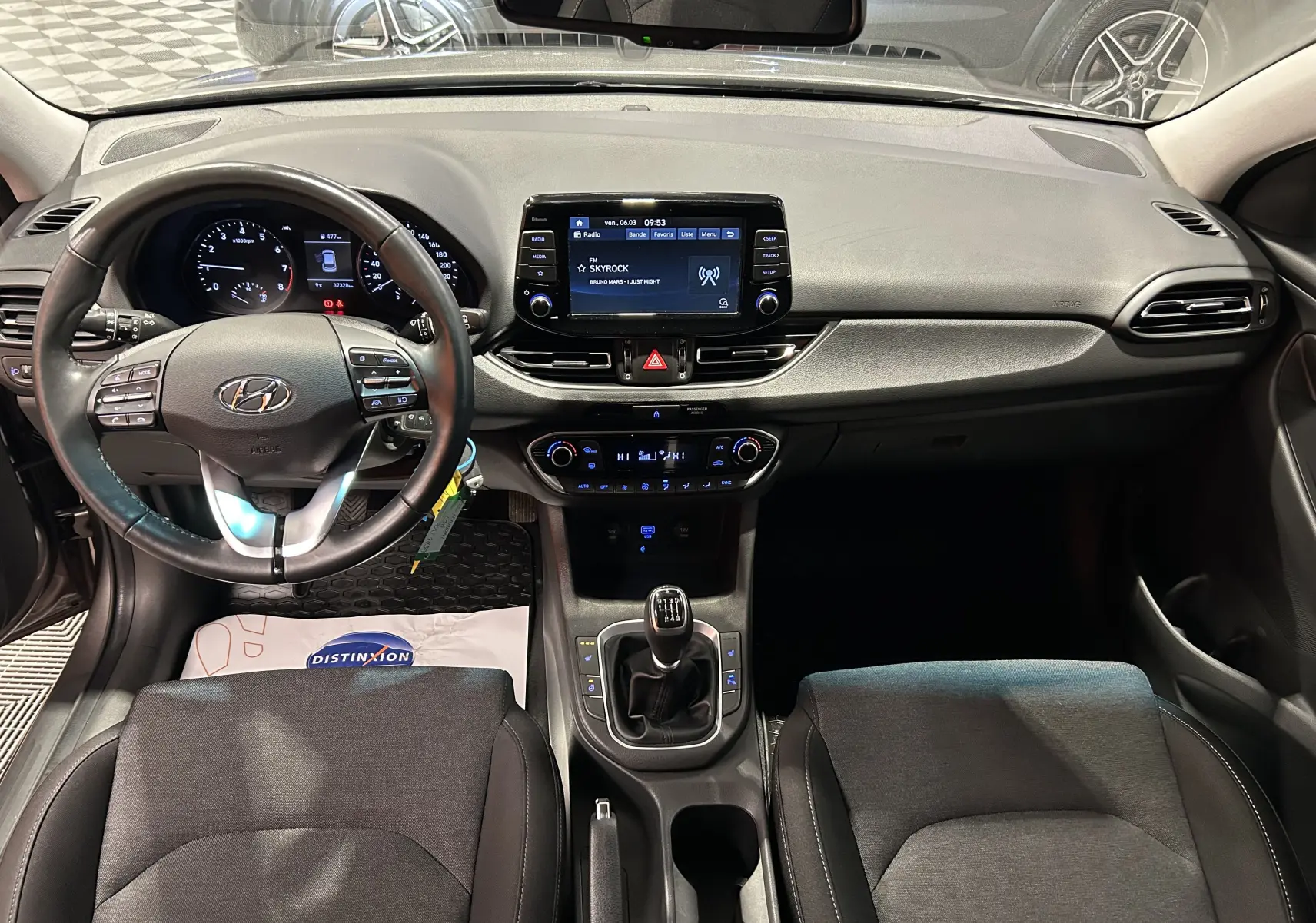 Vue intérieure frontale du tableau de bord et volant cuir de la Hyundai i30 SW 2022 avec écran tactile et boîte manuelle.