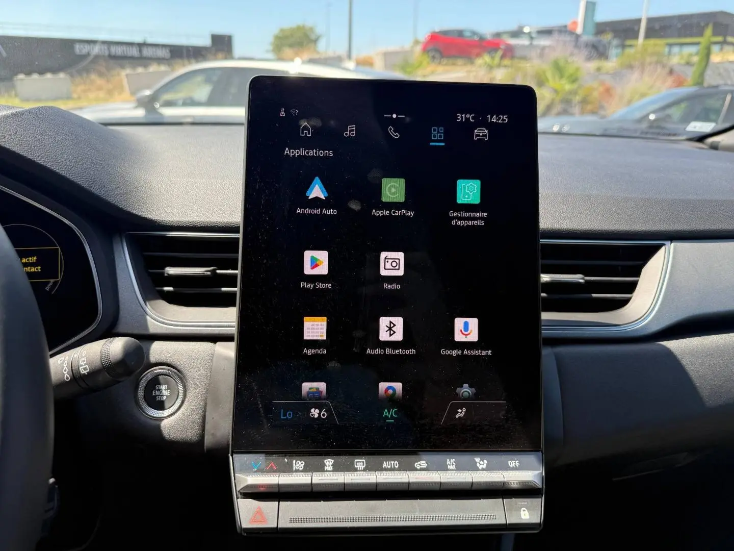 Vue intérieure centrée sur l'écran tactile vertical du tableau de bord du Renault Captur 2025, ambiance noire.