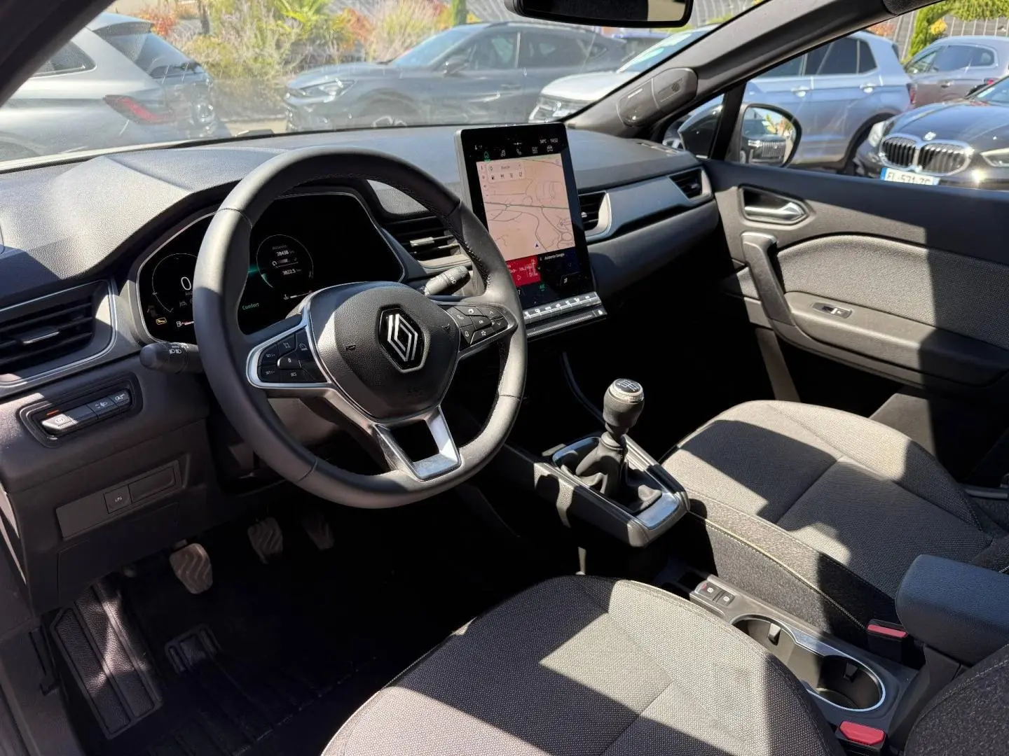 Vue intérieure côté conducteur du Renault Captur 2025, volant multifonction, écran tactile vertical et boîte manuelle.