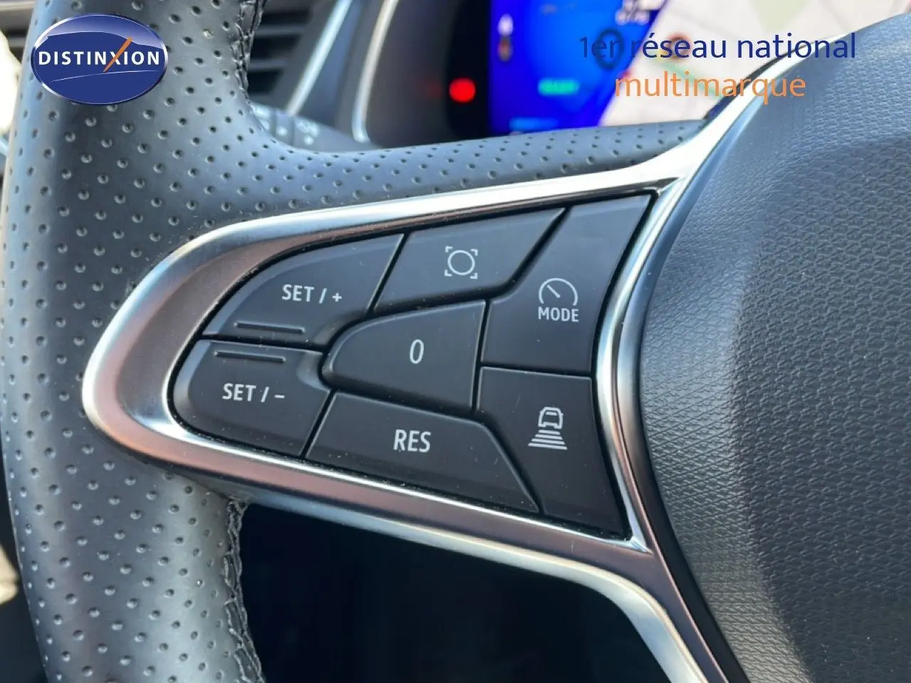 Gros plan sur les commandes de régulateur de vitesse au volant perforé d’une Renault Symbioz noire étoile métal.