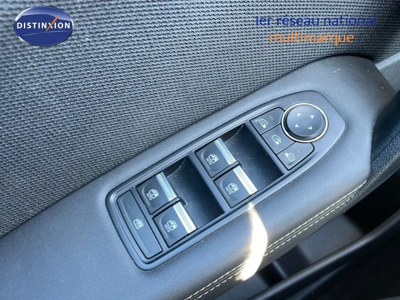 Gros plan sur les commandes des vitres électriques côté conducteur d’une Renault Symbioz noire étoile métal.