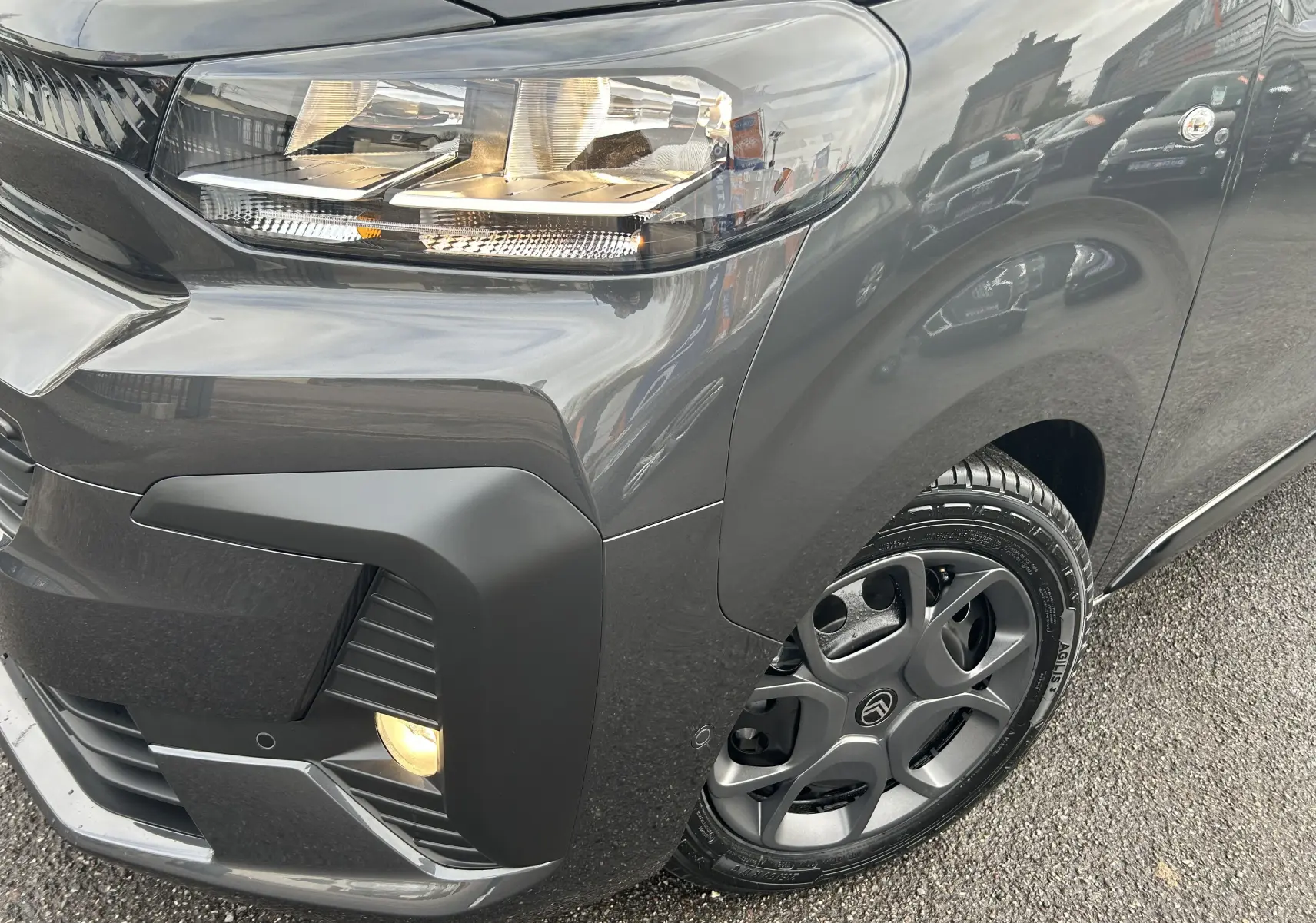 Gros plan sur l'avant droit gris titane métallisé du Citroën Jumpy Cabine Approfondie avec phare et jante distinctive.