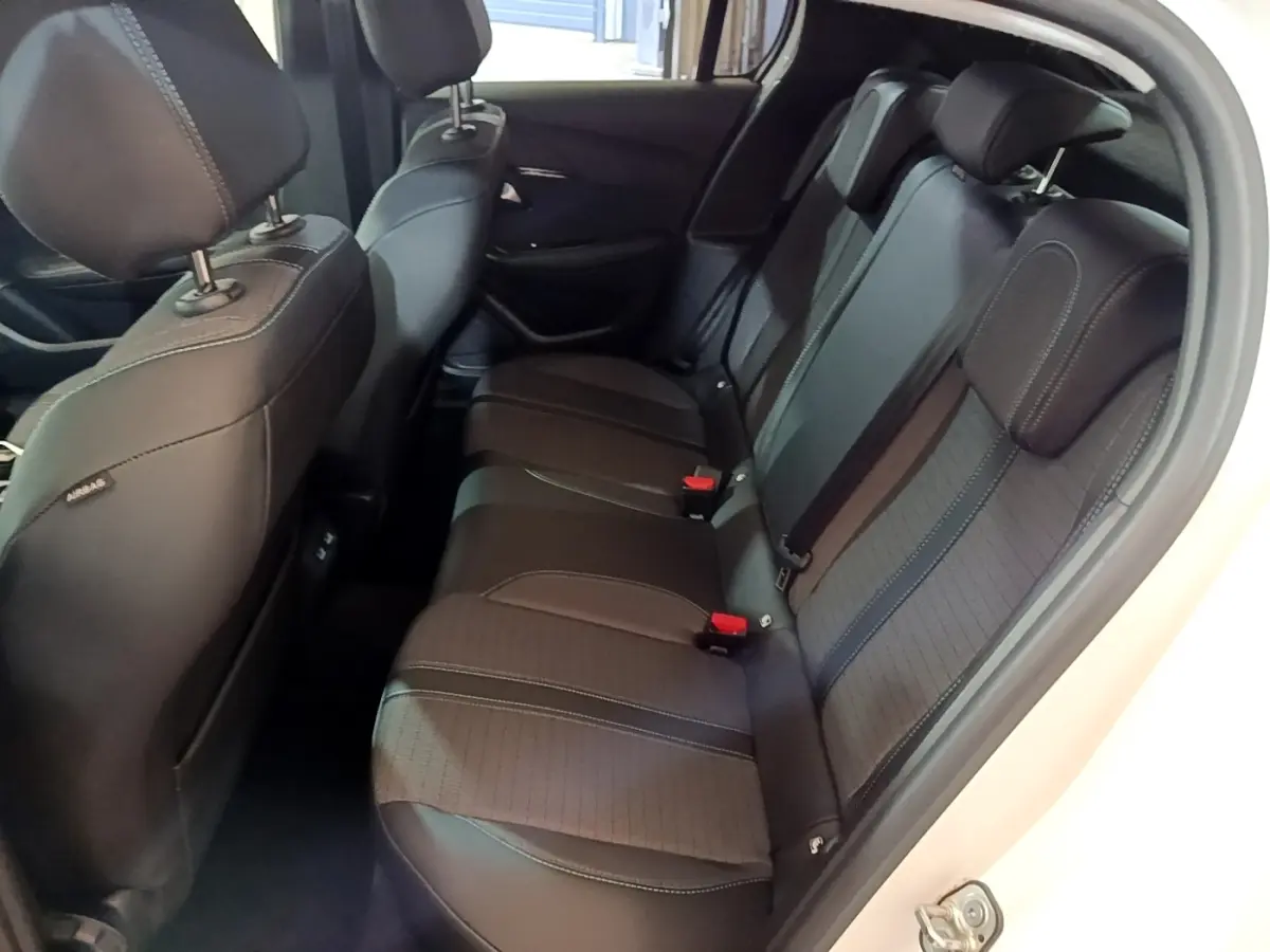 Vue intérieure côté droit des sièges arrière noirs de la Peugeot 208 blanche PureTech 100 S&S Allure Business 2021.