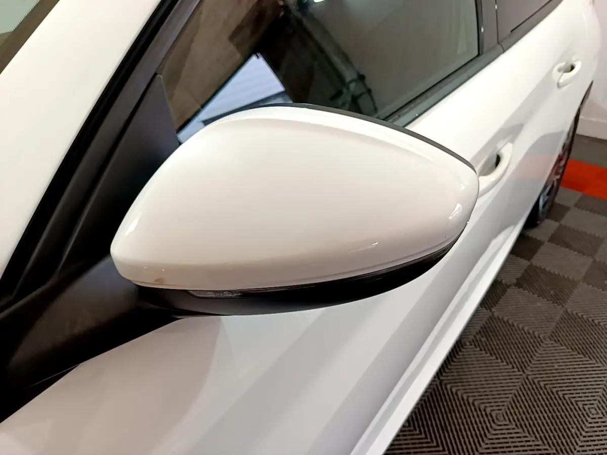 Gros plan sur le rétroviseur droit blanc d'une Peugeot 208 PureTech 100 S&S Allure Business, vue côté droit.