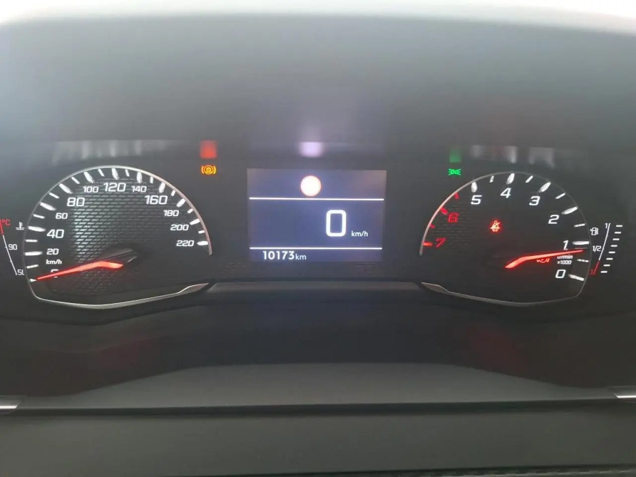 Tableau de bord de Peugeot 208 2024, affichage numérique au centre avec compteur vitesse à gauche et compte-tours à droite.