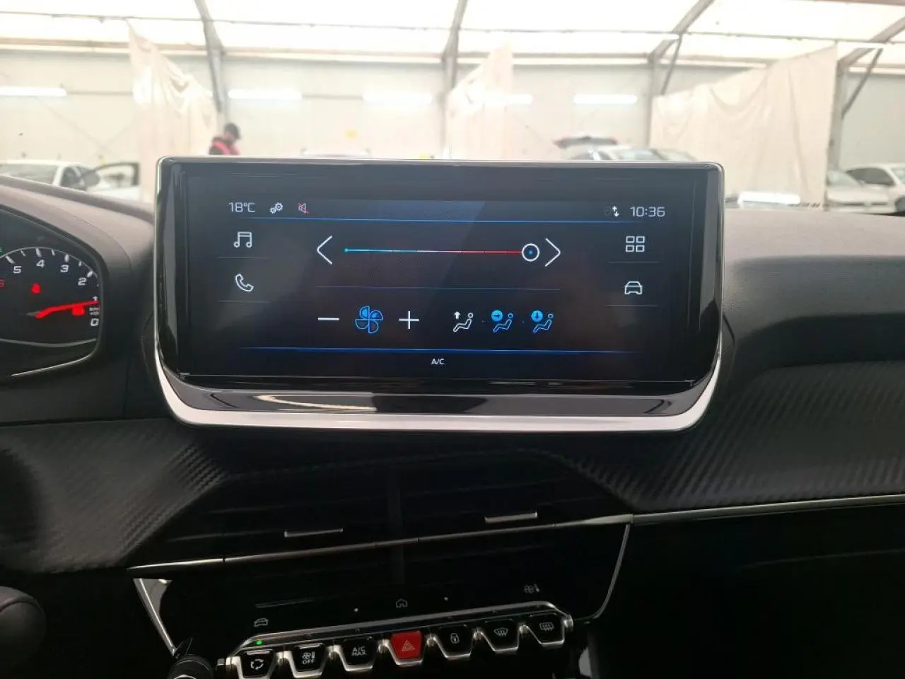 Vue intérieure centrée sur l’écran tactile du tableau de bord de la Peugeot 208 2024, avec commandes climatisation visibles.