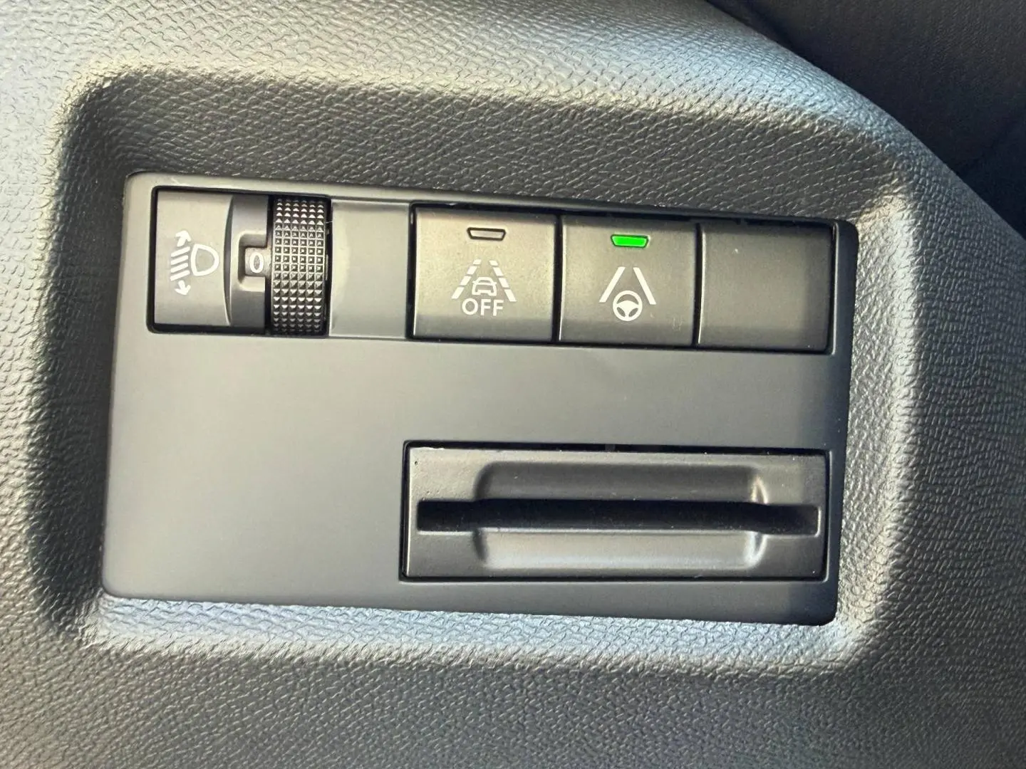 Gros plan sur les commandes d'assistance à la conduite du Citroën C5 Aircross, tableau de bord noir texturé.